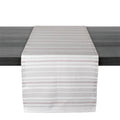 White and gray striped table runner with red accent lines draped across dark surface.