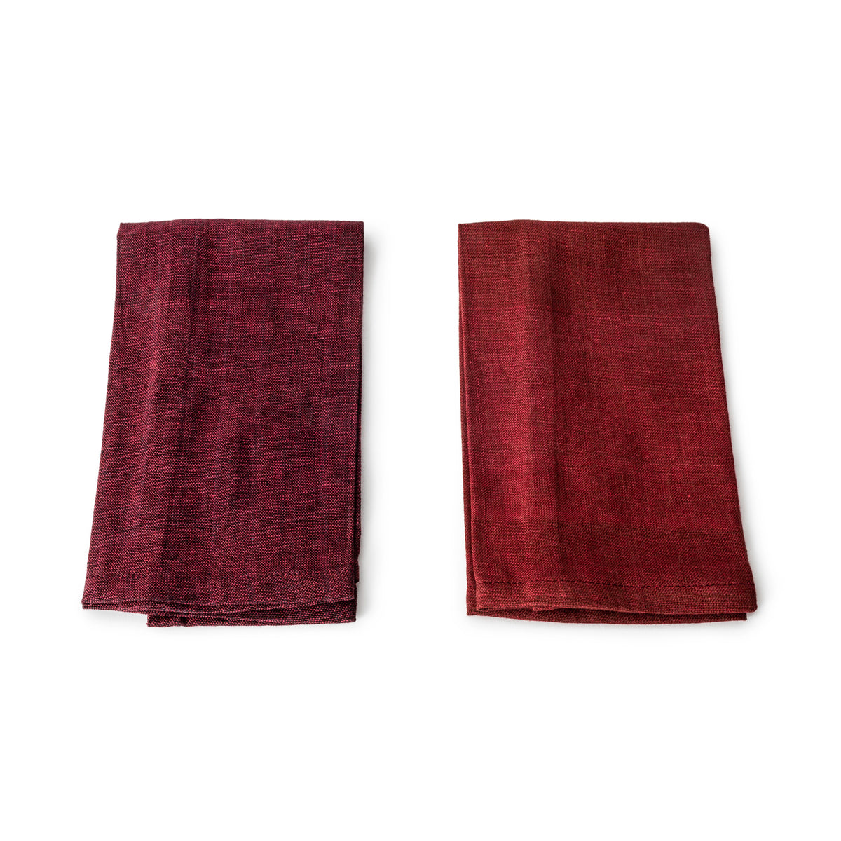 Two folded burgundy linen napkins displayed side by side showing textured weave fabric.