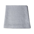 Four light gray linen napkins stacked and folded.