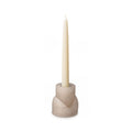 Beige concrete candle holder with taper candle inserted in top opening and tealight cup on lower section.