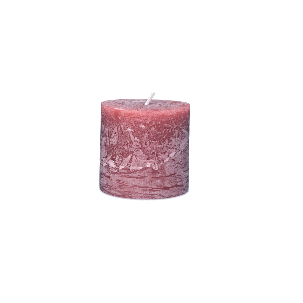 Mauve and pink pillar candle with textured surface and white wick on top.