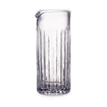 Clear glass pitcher with vertical ribbed pattern and curved handle spout.