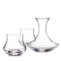 Three clear glass vessels including a rocks glass, wine glass, and decanter with curved sides.