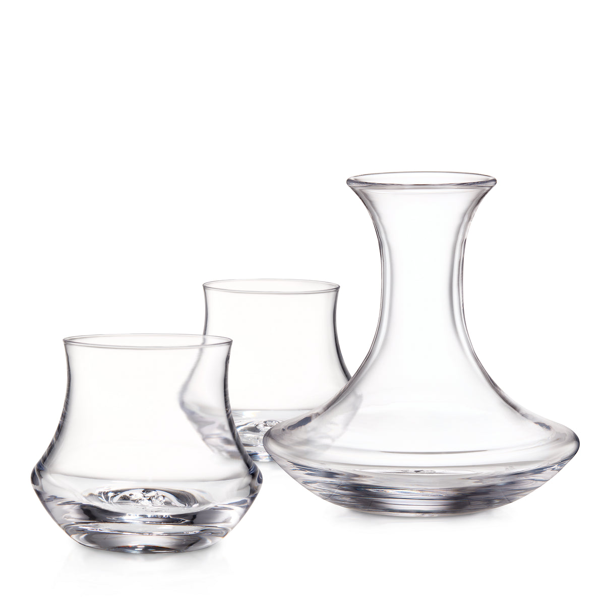 Three clear glass vessels including a rocks glass, wine glass, and decanter with curved sides.