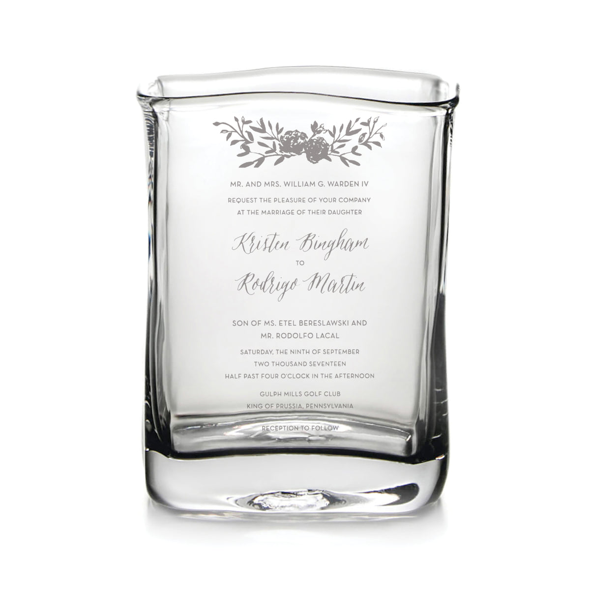 Clear glass vase engraved with wedding invitation text and floral design.