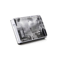 Black and white photo block with cityscape image featuring tall buildings and cloudy sky.