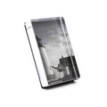 Vertical acrylic photo block displaying a black and white lighthouse image with attached stand.