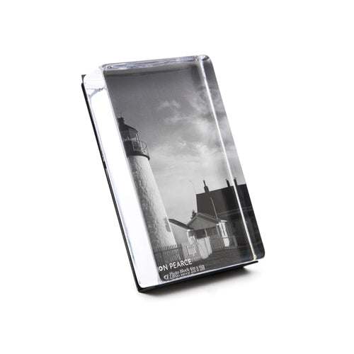 Vertical acrylic photo block displaying a black and white lighthouse image with attached stand.