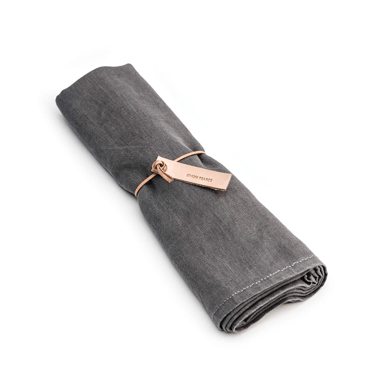 Grey linen table runner rolled and tied with a rose gold band.