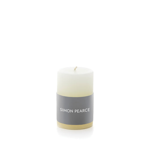 Ivory pillar candle with gray band label and cream-colored base.