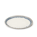 Round plate with cream center and blue brushstroke rim pattern on gray stoneware.