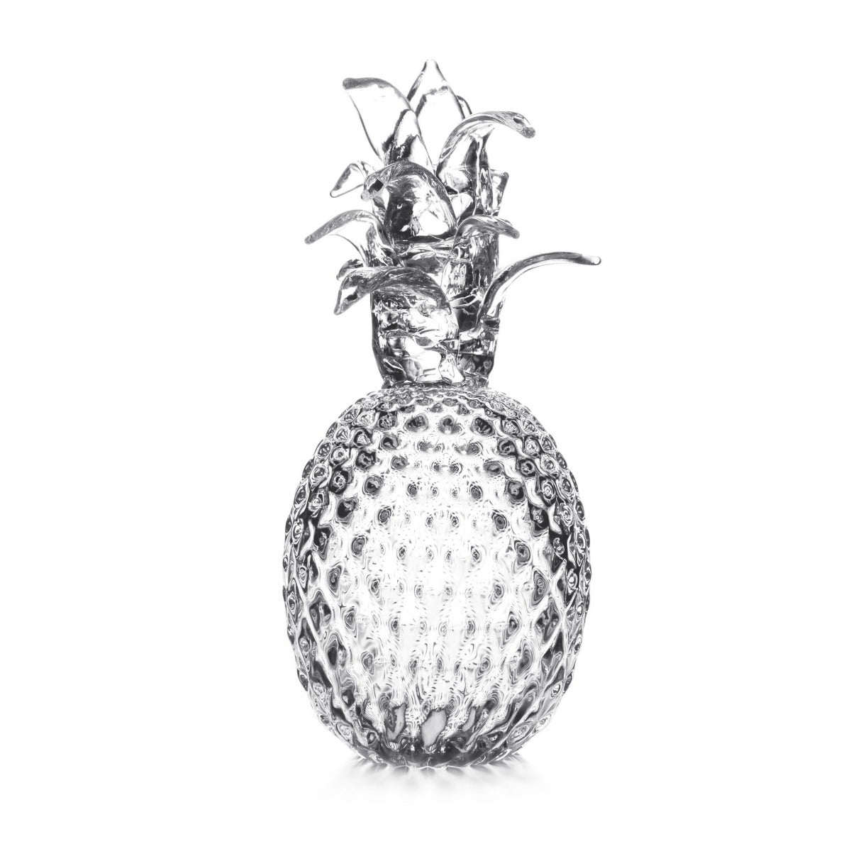 Fresh pineapple with textured skin and green crown leaves against white background.