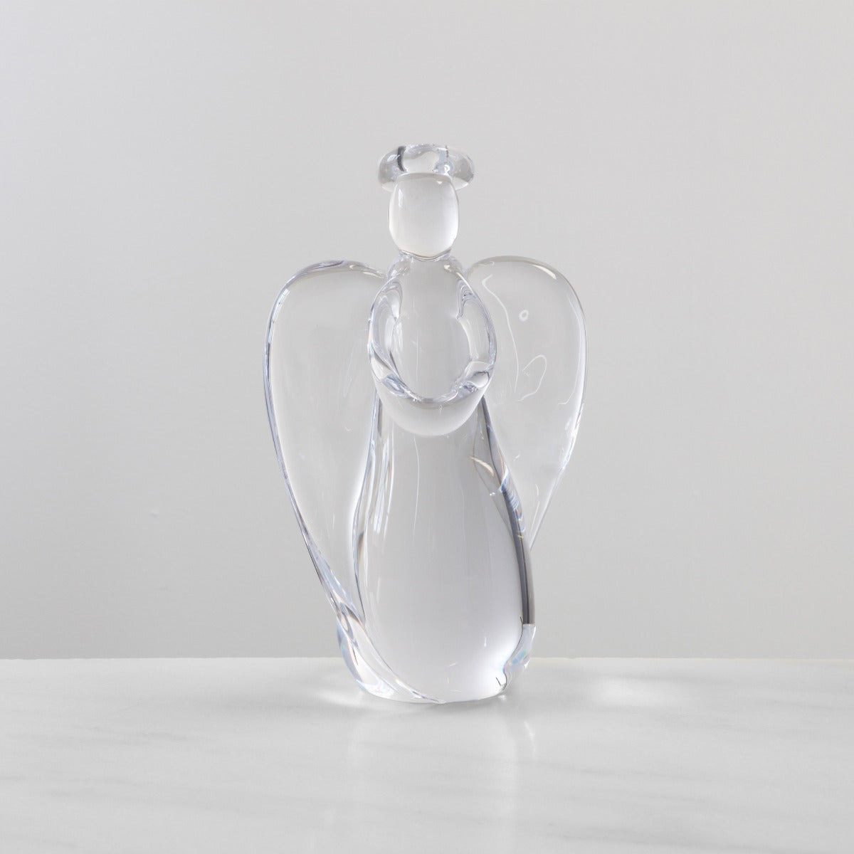 Clear glass angel figurine with twisted body design and large wings, approximately 9 inches tall.