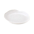 White ceramic side plate with curved rim and subtle textured surface.