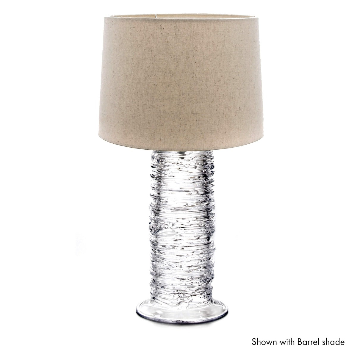 Clear textured glass cylindrical base lamp with beige linen drum shade.
