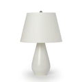 Cream pottery table lamp with teardrop-shaped base and conical fabric shade with brushed metal finial.