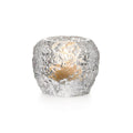 Silver textured tealight holder with lit candle visible inside.