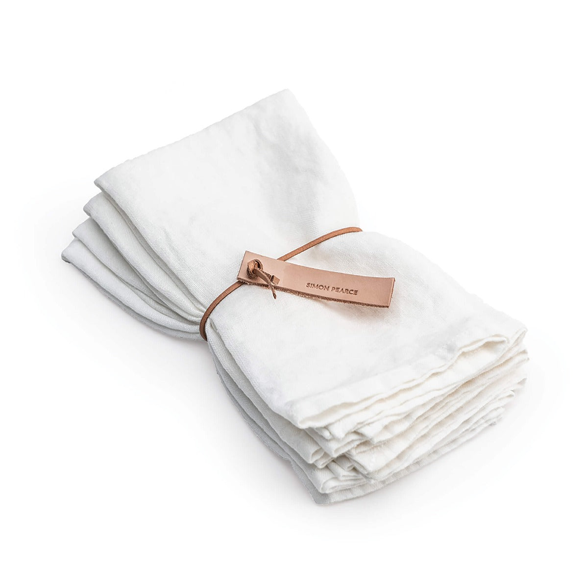 Four white linen napkins with hemmed edges, tied together with a copper-colored leather band.