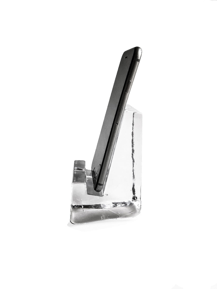 Black smartphone resting in clear acrylic stand with angled support base.