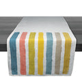 Linen table runner with vertical stripes in teal, coral, yellow, and beige on white background.