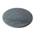 Round grey soapstone board with flat surface and slightly beveled edge.