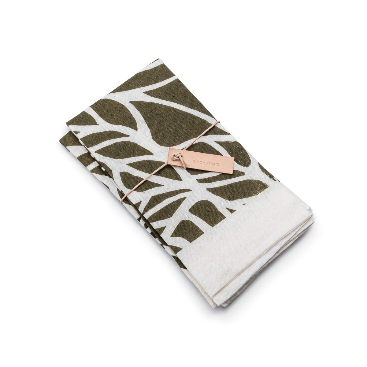 Two folded napkins with olive-colored block print leaf pattern on white background, bound with a tan label.