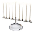 Menorah with nine ivory taper candles in silver-tone holders on a white stone base.