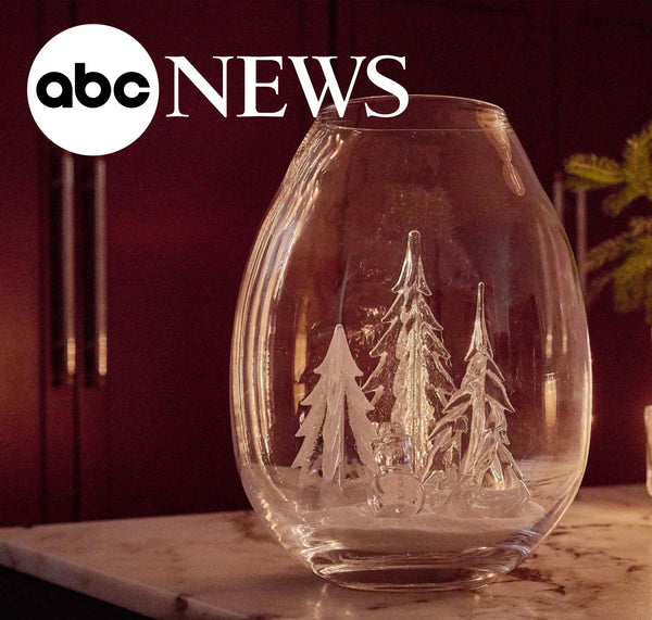 ABC News feature: Simon Pearce handblown glass globe with glass trees inside, displayed on a marble surface in warm ambient light