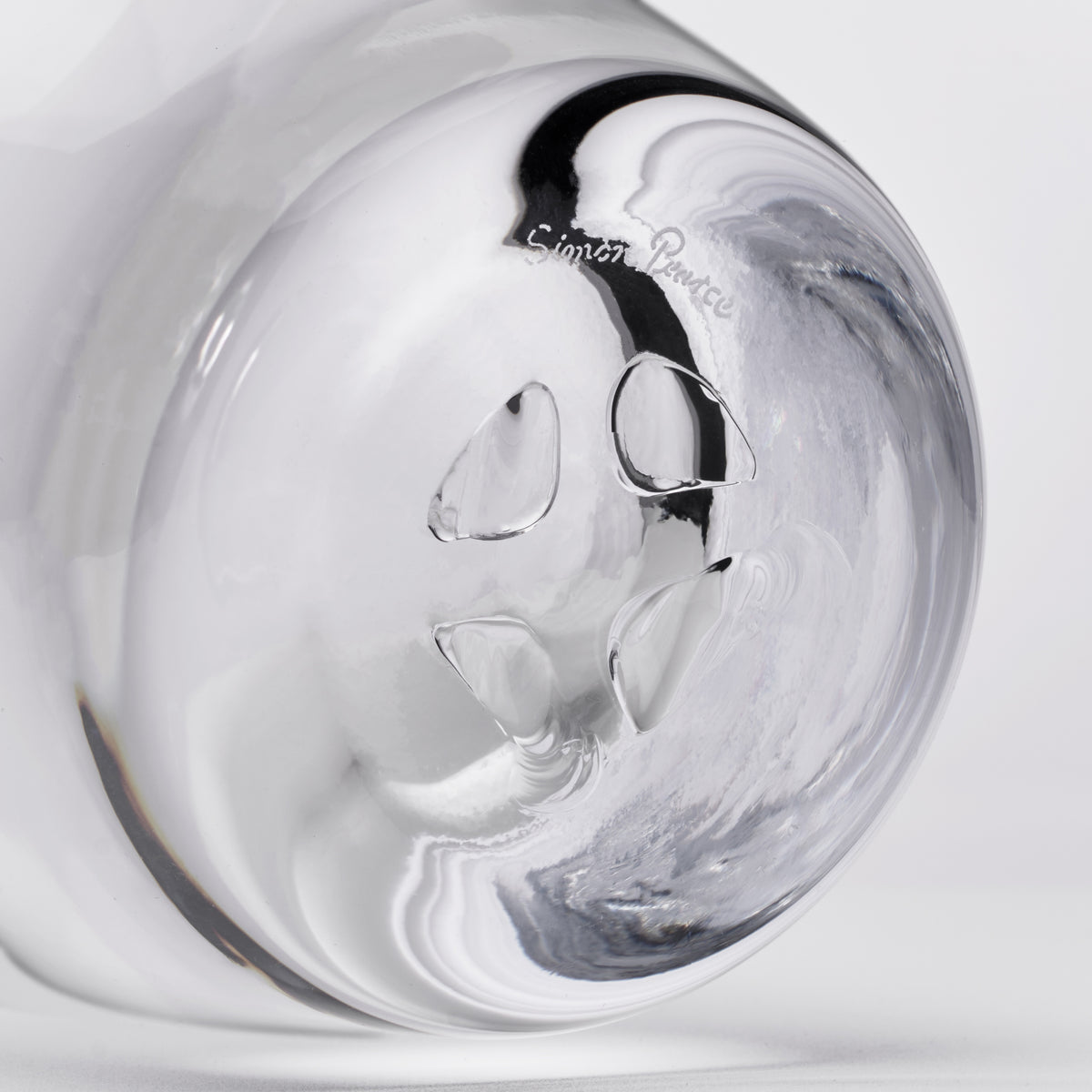 Clear glass decanter with black swirl pattern and maker's mark on rounded body.