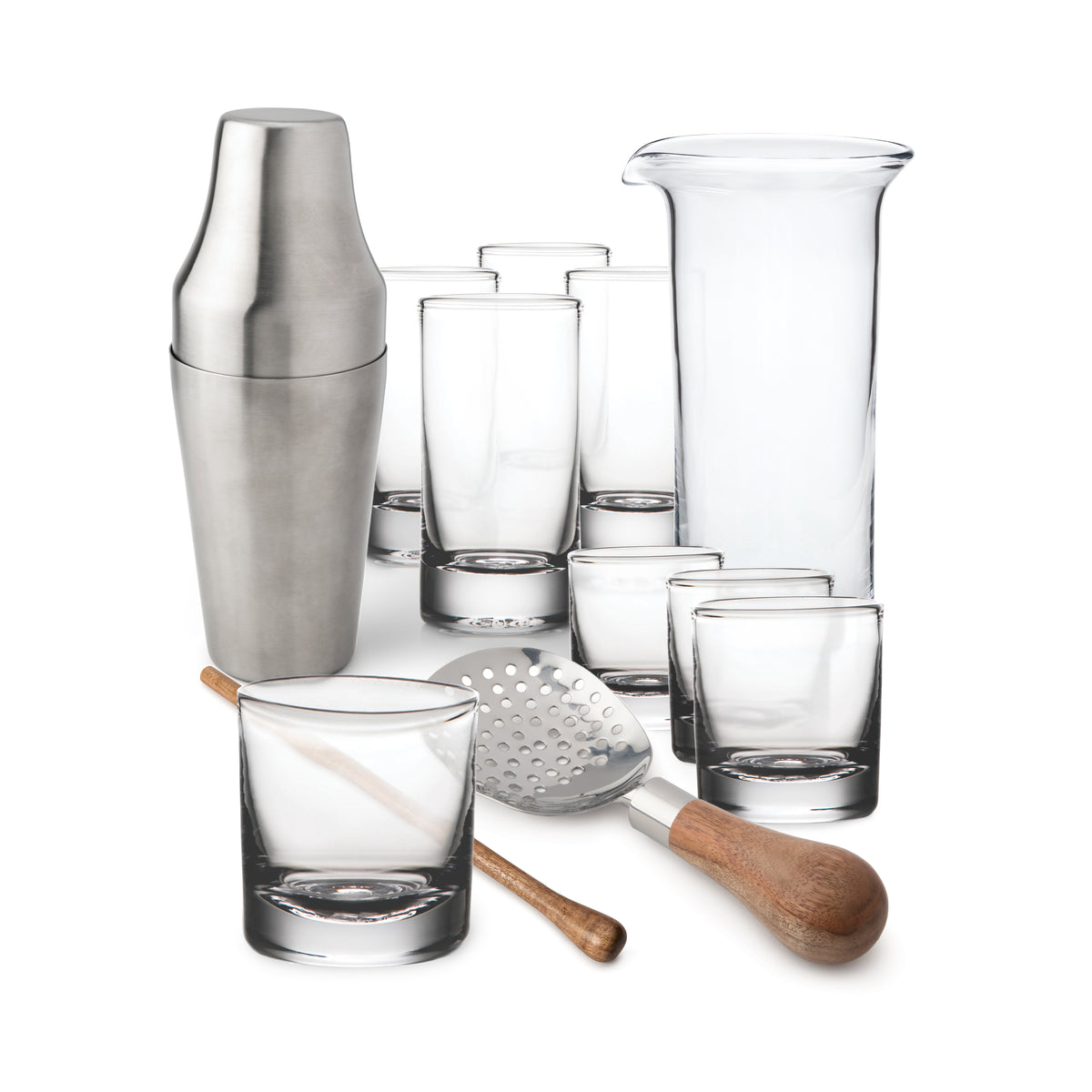 Stainless steel cocktail shaker, mixing glass, jigger, bar spoon, muddler, and six drinking glasses arranged together.