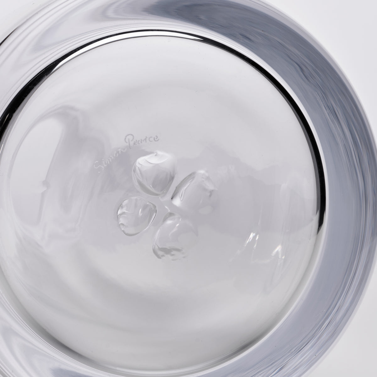 Clear glass carafe with ice cubes inside, viewed from above showing the circular opening and gray-tinted rim.