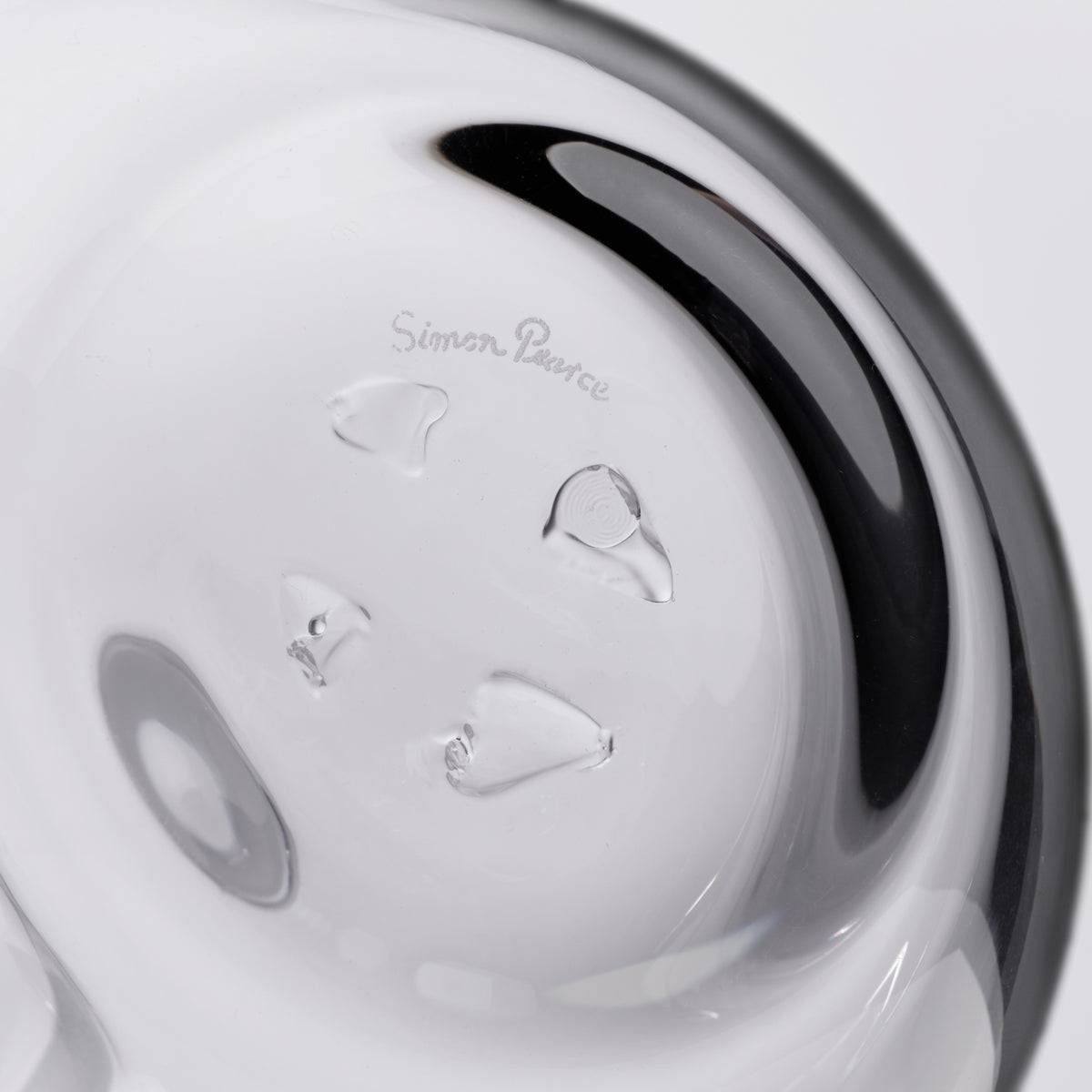 White glass decanter with black curved handle and etched branding on the body.