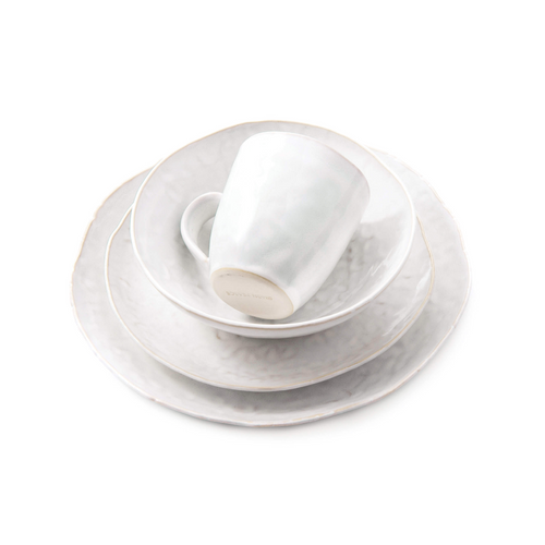 White dinnerware set with stacked plates, bowl, and mug featuring cloud-like surface texture.