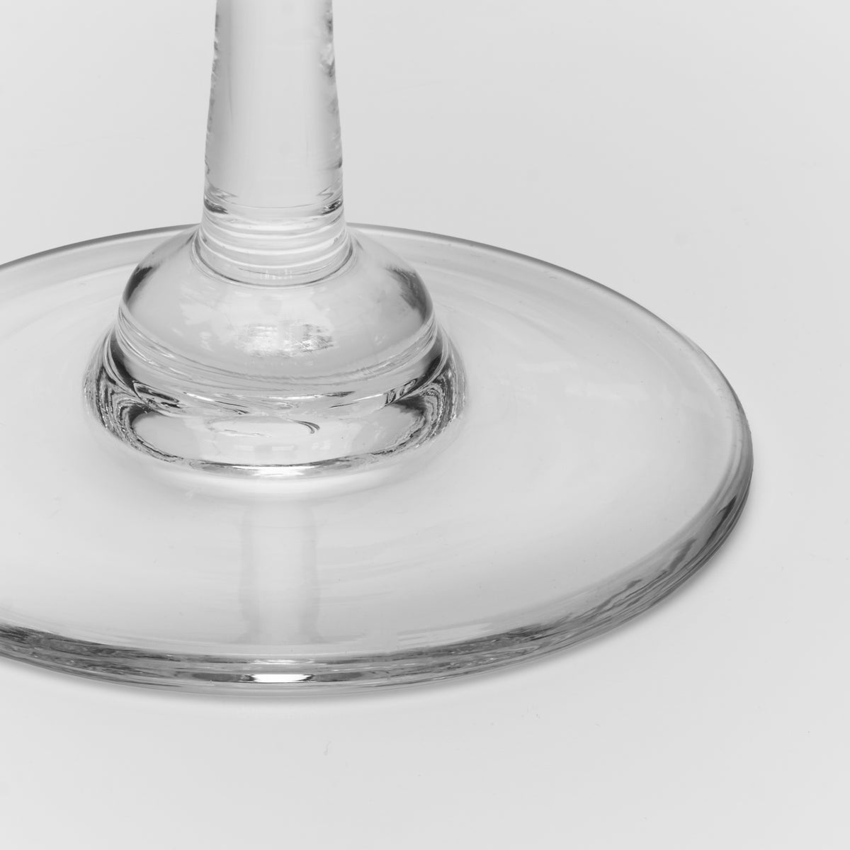 Clear glass candlestick with a tapered stem and wide circular base, shown from above against a neutral background.