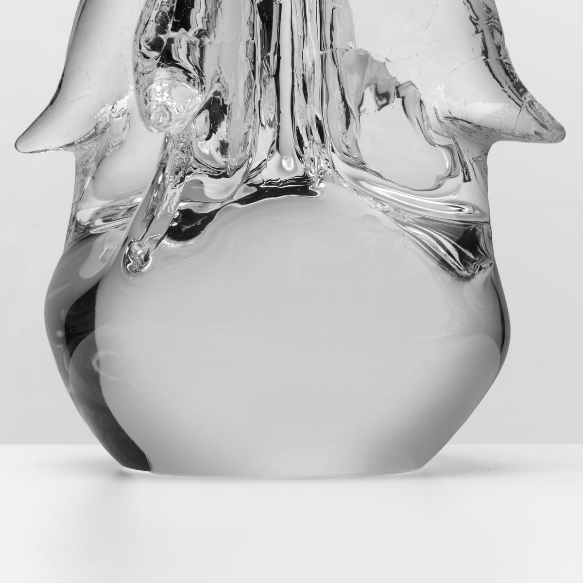 Clear glass four-sided candle with crackle texture on top and smooth rounded base.