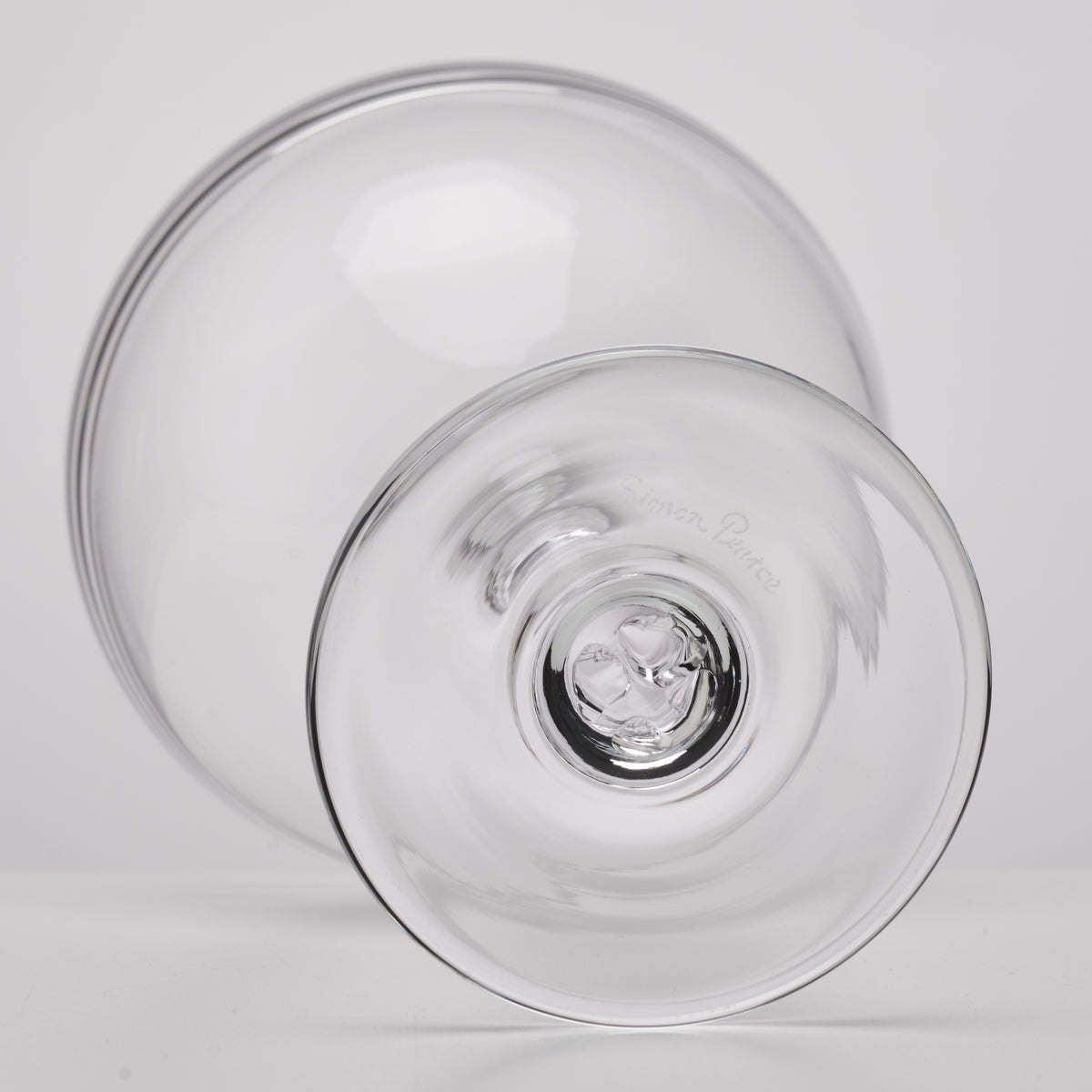 Two clear glass coupes with wide bowls and thin rims, shown from above and side angle.