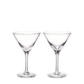 Two clear glass martini glasses with conical bowls and long stems on white background.