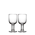 Two clear glass wine goblets with pedestal bases and rounded bowls.