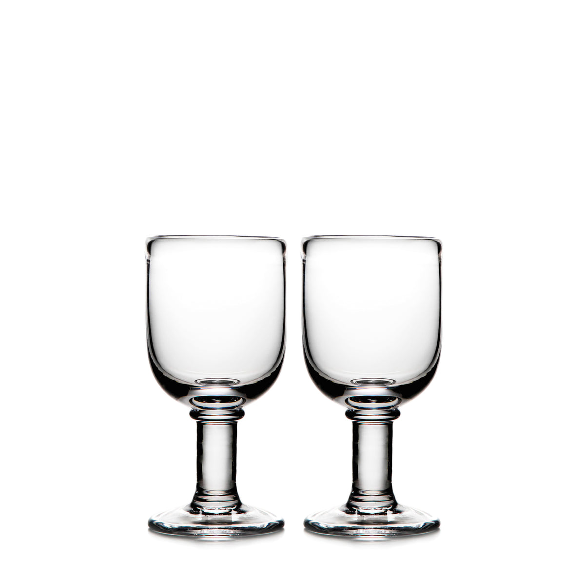 Two clear glass wine goblets with pedestal bases and rounded bowls.