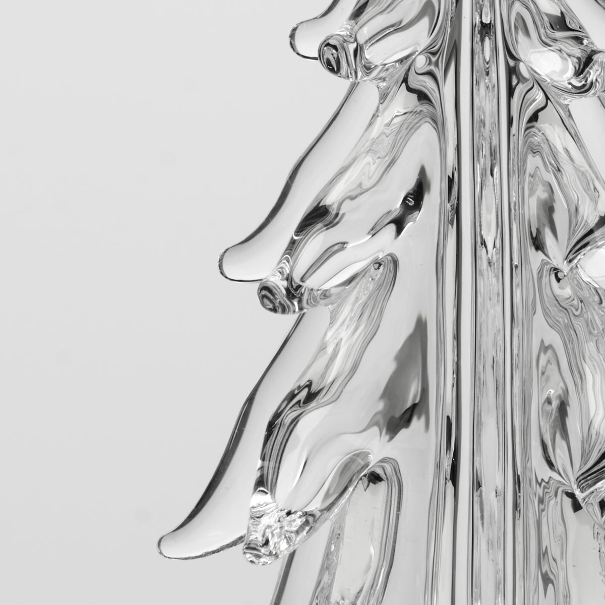 Clear glass five-sided ornament with curved edges and reflective surface against white background.