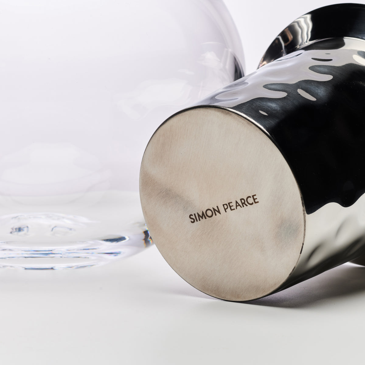 Black and white wine chiller with brushed metal base, textured black handles, and "Simon Pearce" branding.