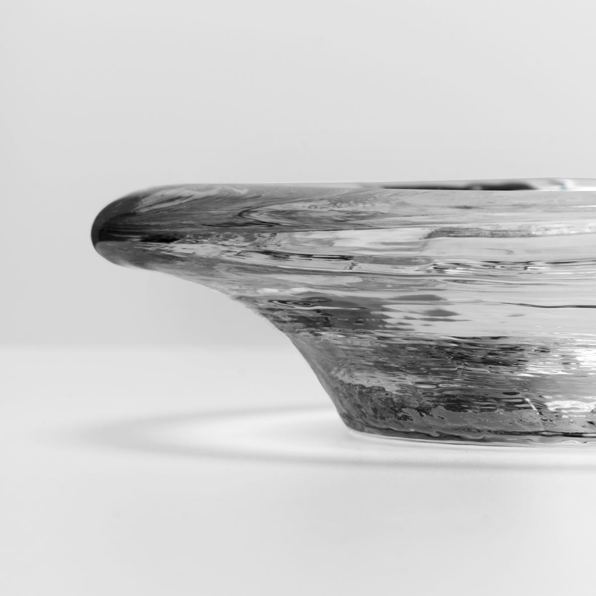 Black and white marbled resin coaster with curved rim and organic wood-grain pattern throughout.