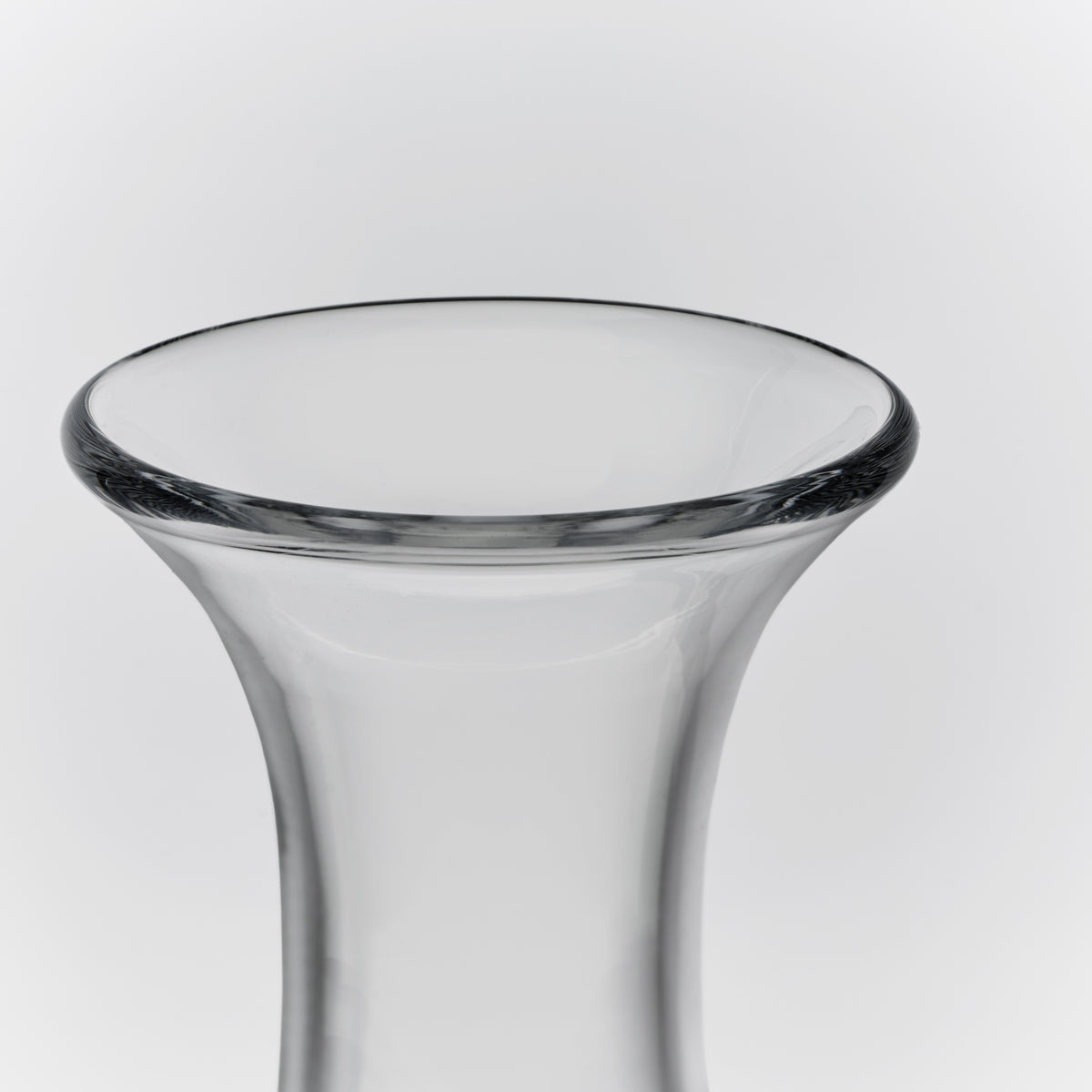 Clear glass wine decanter with wide flared rim and tapered cylindrical body.