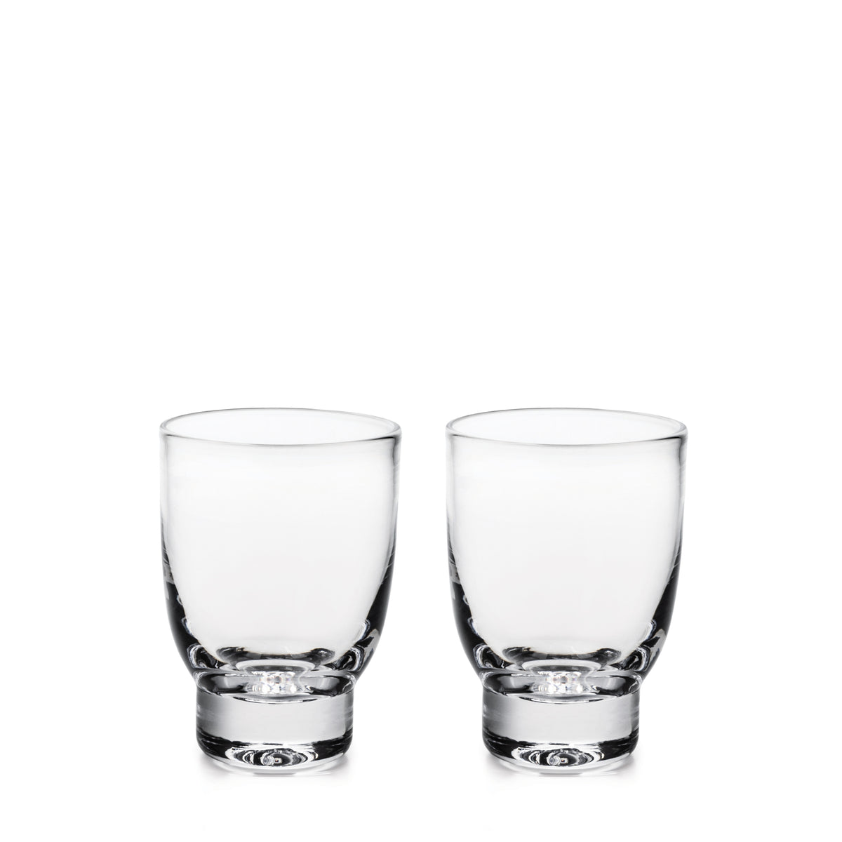 Two clear glass tumblers with thick bases displayed side by side.