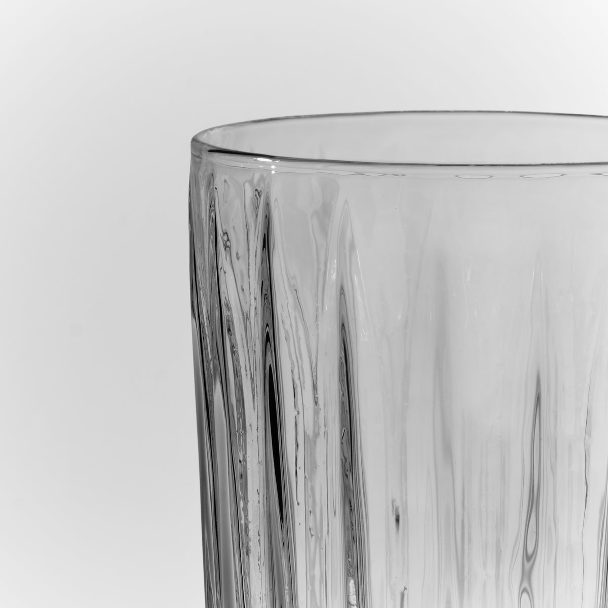 Clear highball glass with vertical textured ridges and a flat rim.