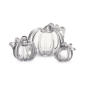 Three clear glass pumpkins in varying sizes with ribbed details and decorative leaf stems on top.