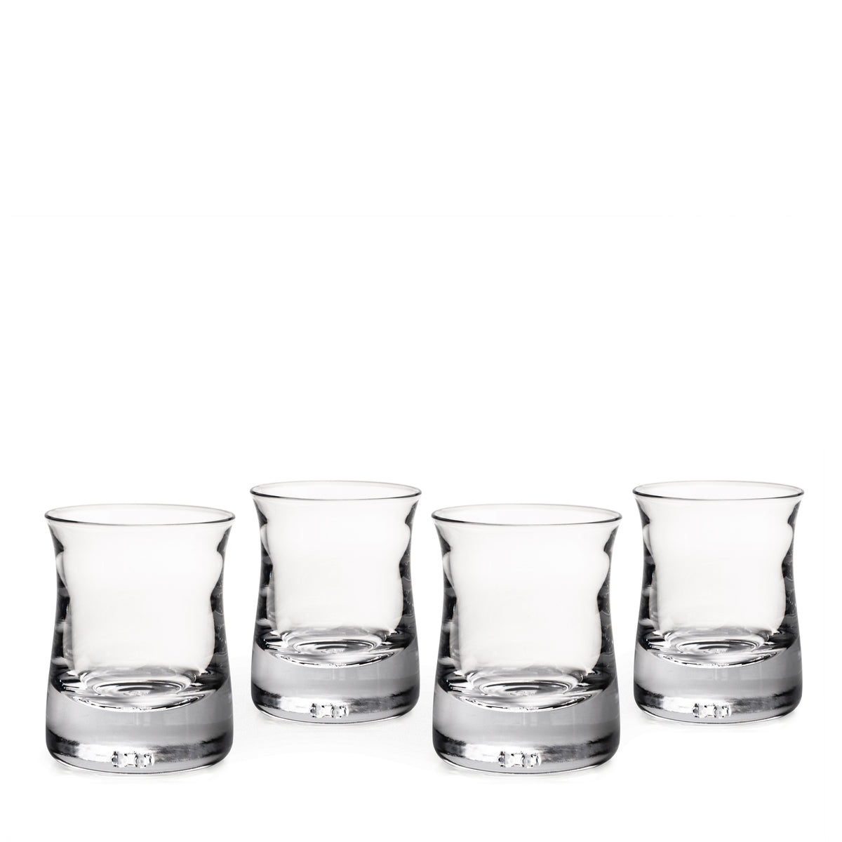 Set of four clear glass whiskey tumblers with weighted bases and tapered sides.