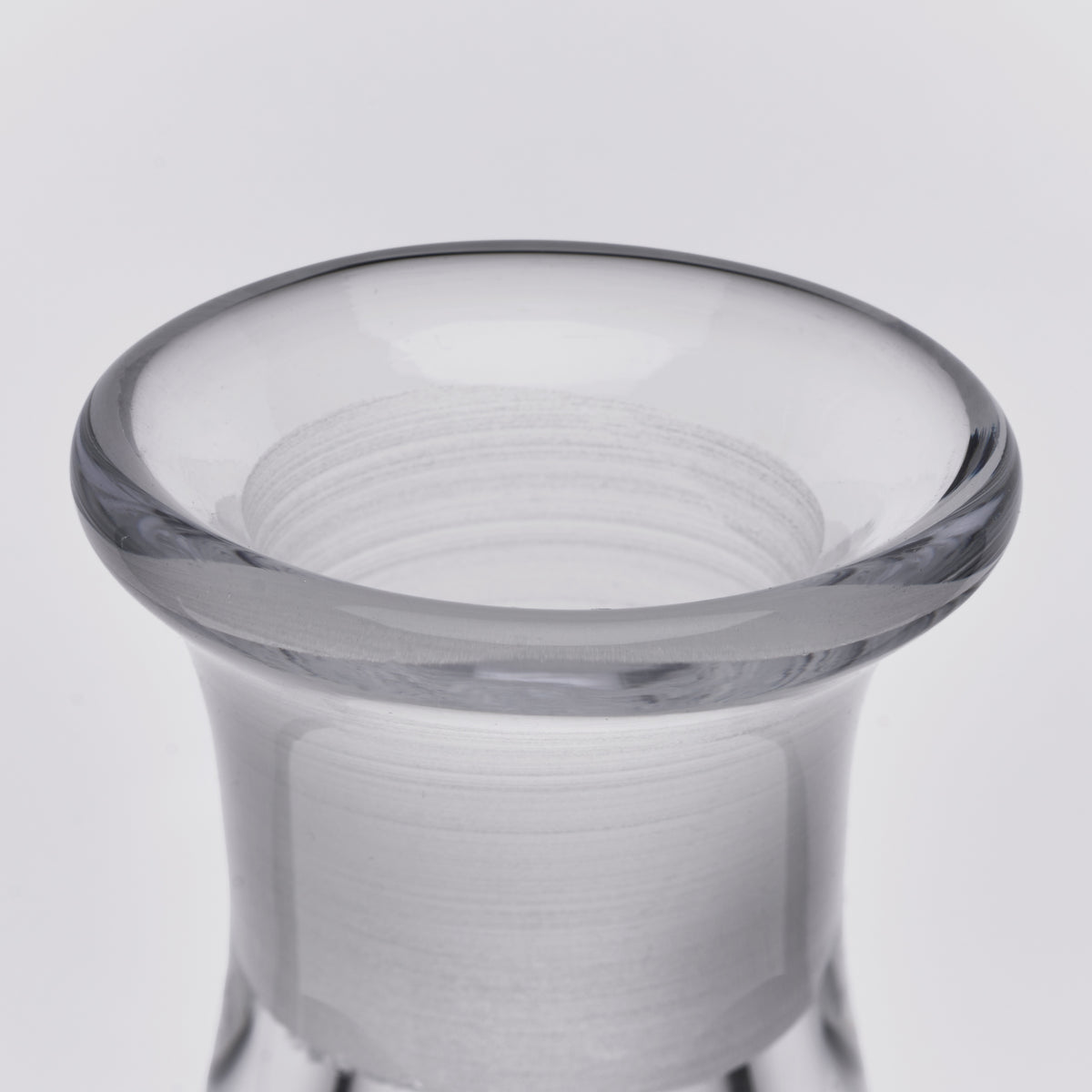 Clear glass decanter with frosted body and gray-toned rim, viewed from above.
