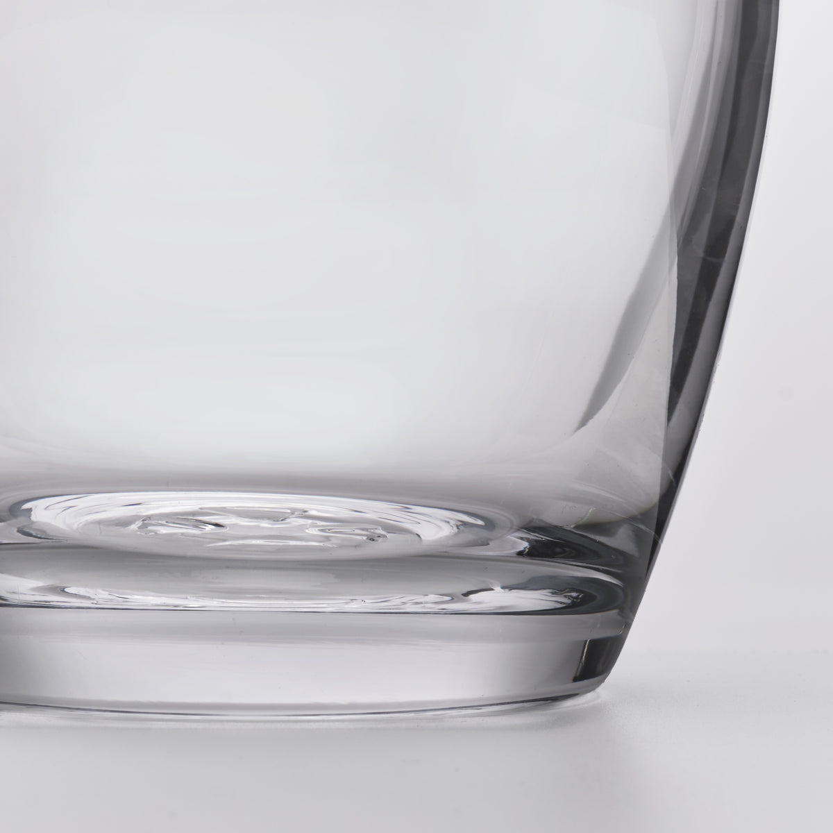 Clear glass decanter with curved body and wide base, shown from a side angle.