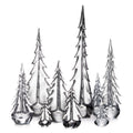 Group of seven clear glass evergreen tree figurines in varying heights with pointed tops and layered branches.